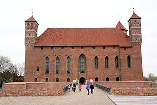 0152 Burg Heilsberg in Lidzbark Warmiński - erbaut von 1350 - 1401; Ordensburg des Deutschen Ordens. Touristen gehen in das Backsteingebude, in dem sich heute ein Regionalmuseum befindet