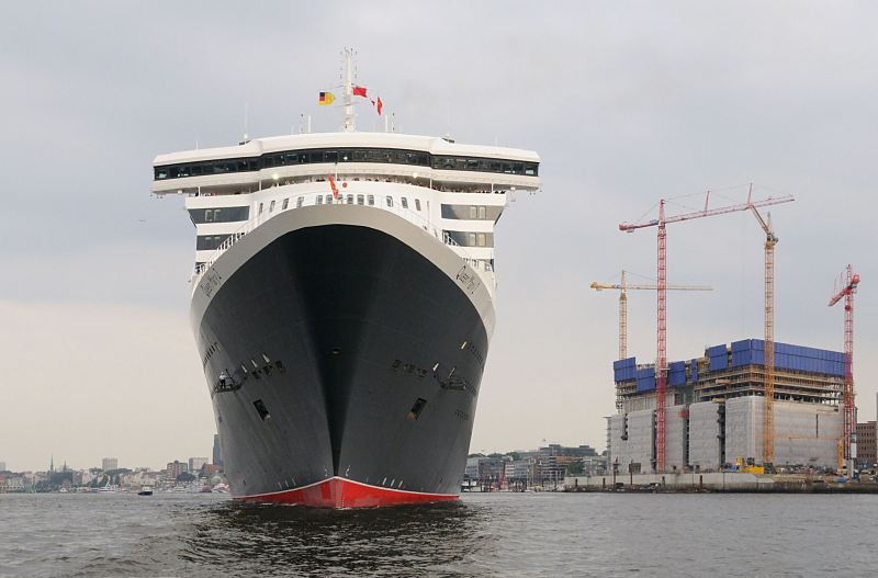 Schiffsfotos aus Hamburg - Bug des Kreuzfahrtschiffs Queen Mary 2, Baustelle Elbphilharmonie. 011_62_4720 Die Queen Mary hat ihren Liegeplatz am Kreuzfahrt-Terminal im Hamburger Hafen erreicht und wendet ohne Hilfe von Schleppern auf der Elbe. Rechts die Riesenbaustelle der zuknftigen Hamburger Elbphilharmonie zu der der ehemalige Kaispeicher am Sandtorhafen umgebaut wird - vier hohe Baukrne stehen auf dem Bauplatz. www.hamburg-fotograf.com