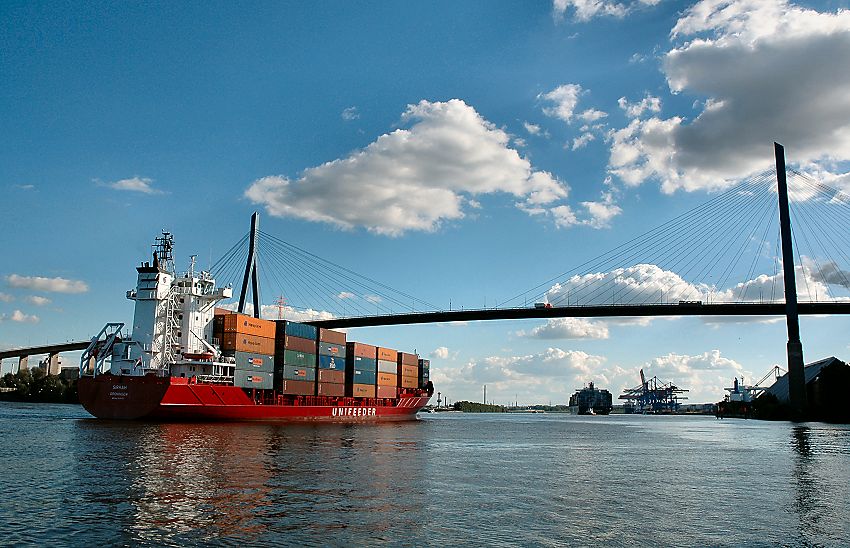 011_14349 ein Container Feeder kommt von der Elbe - der rote Container Carrier fhrt unter blauem Hamburger Himmel auf dem Khlbrand zum Container Terminal Altenwerder.