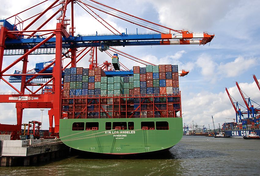 011_15611 das imposante Heck eines Containerschiffs am Kai vom Eurogate Terminal im Waltershofer Hafen - die Frachtcontainer sind auf der XIN LOS ANGELES in mehreren Reihen hoch gestapelt - ein Container schwebt unter der Containerbrcke und wird an Land gebracht; links unten warten schon die Container Carrier, um die Fracht weiter zu transportieren.  www.fotograf-hamburg.de