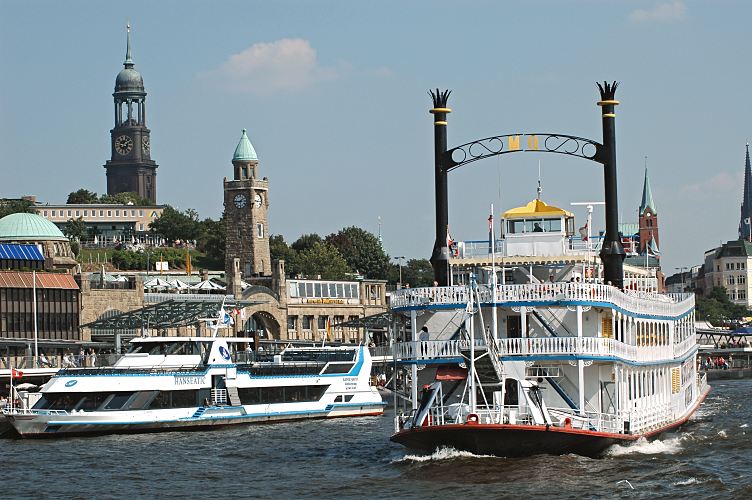 Hamburg Bilder St. Pauli Landungsbrcken, Fahrgastschiffe der Hafenrundfahrt / Michaeliskirche  011_26078 Ein Raddampfer der Hafenrundfahrt hat gerade mit Touristen an Bord seine Sightseeing-Tour durch den Hamburger Hafen begonnen. Ein anderes Fahrgast-Schiff liegt am Ponton der St. Pauli Landungsbrcken - die Rundfahrt durch den Hamburger Hafen und die Speicherstadt ist eine beliebte Touristenattraktion. Hinter dem Gebude der Jugendherberge am Stintfang ragt das Hamburger Wahrzeichen, der Turm der Michaeliskirche empor. Auf der Plattform unter der Kuppel geniessen die Hamburger Touristen den Ausblick ber die Hansestadt, die Elbe und den Hafen. www.hamburg-fotograf.com