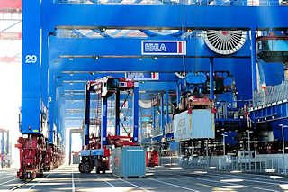 0922 Ein Container wird gerade auf den Kai abgesenkt, eine andere Metallbox von einem Portalhubwagen aufgenommen - Bilder aus dem Hafen Hamburgs, Containerterminal Burchardkai.