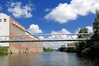 6210 Lagergebäude / Speicher am Kanalufer des Billbrookkanals in Hamburg Billbrook - Leitungen führen über den Kanal - blauer Himmel, weisse Wolken.