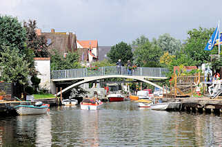 1373  Gracht mit Fussgängerbrücke - Sportboote am Ufer des Kanals.