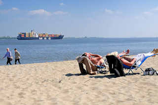 7045 Elbufer bei Stade / Containerschiff auf der Elbe - Strandbesucher in Liegen / Liegestühle im Sand in der Sonne - Spaziergänger.
