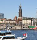 011_28-5341 Blick ber die Elbe zu den St. Pauli Landungsbrcken und Vorsetzen. Das Museumsschiff Rickmer Rickmers liegt am Ponton; ein Fahrgastschiff mit Touristen an Bord macht seine Tour ber die Elbe durch den Hamburger Hafen - am Bug des Schiffs weht die Hamburger Flagge. Im Hintergrund der Turm der St. Michaeliskirche (Michel), dem Wahrzeichen Hamburgs. Davor die kleine Gustav-Adolf-Kirche, die 1907 als Seemannskirche fr die skandinavischen Seeleute erbaut wurde. www.hamburg- fotograf.com