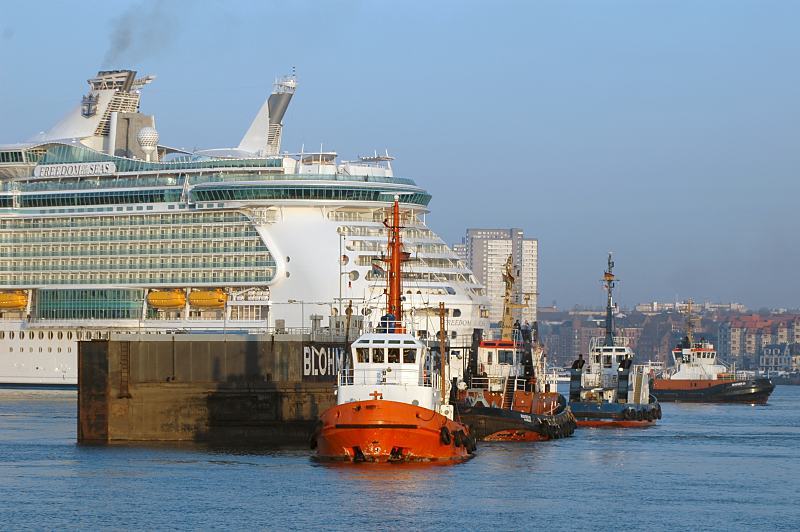 Hamburger Fotografie - Hamburg Bilder aus dem Hafen der Hansestadt Hamburg - eindocken Passagierschiff FREEDOM OF THE SEAS. 011_71_6746 Das zweitgrte Passagierschiff de Welt, die FREEDOM OF THE SEAS dockt im Trockendock Elbe 17 der Hamburger Werft Blohm + Voss ein. Das Kreuzfahrtschiff hat eine Lnge von 338 m und eine Breite von 56 m whrend das Dock die Mae 351 x 59 m aufweist. Der vordere Teil des Schiffs ist schon in das Dock eingefahren - drei Schlepper warten mit dem schwimmfhigen Sperrtor auf die Beendigung des Eindockmanvers, um das Trockendock dann zu verschlieen 