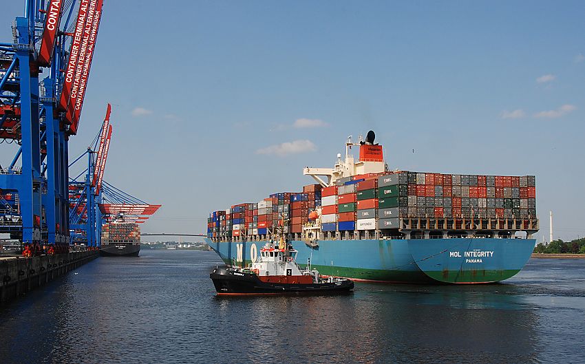 011_15578 ein Schlepper zieht das Schiff an die Kaianlage des Container Terminals Altenwerder- die Containerbrcke ist noch hochgeklappt - ein anderer Containerfrachter wird am Kai des Hamburger Hafens entladen; im Hintergrund die Khlbrandbrcke und die Elbe. 