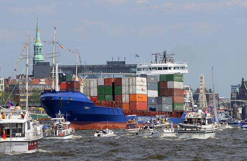 03_14053  Hafengeburtstag im Hamburger Hafen - Sportschiffe und Motoryachten fahren auf der Elbe im Hamburger Hafen vor den St. Pauli Landungsbrcken - an der Hafenpromenade ist das Riesenrad zu erkennen, re. davon die Giebel der Lagergebude in der Hamburger Speicherstadt -  lks. der Kirchturm der Hamburger Hauptkirche St. Katharinen. Der Containerfeeder HERM J bahnt sich seinen Weg durch den Trubel auf dem Wasser - der Frachter ist mit Containern hoch beladen.  www.christoph-bellin.de