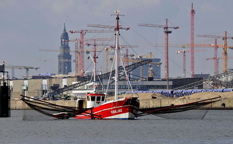 011_26068 das Fischerboot LUISE /HBK 103 aus Hamburg Finkenwerder fischt auf der Elbe vor den Elbbrcken; links und rechts werden ber Ausleger die Netz ins Wasser gelassen. Das Fischereiboot ankert im Strom und bei abfliessendem Wasser / Ebbe werden die Fische gefangen. Im Hintergrund Baukrne, die auf den Baustellen der Hamburger Hafencity stehen - dahinter das Wahrzeichen Hamburgs die St. Michaeliskirche. Die Hamburger Hauptkirche ist einer der Sehenswrdigkeiten fr Hamburg-Touristen und wird von den Einwohnern der Hansestadt auch liebevoll "Michel" genannt.   www.christoph-bellin.de