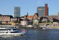 011_26070 ein Fahrgastschiff hat Hamburg-Touristen an Bord, denen der Hamburger Hafen, die Speicherstadt und die Riesenbaustelle der zuknftigen Hamburger Hafencity gezeigt wird - die Hamburger Flagge weht im Fahrtwind am Bug des weissen Schiffs. Im Hintergrund die Pontonanlage der St. Pauli Landungsbrcken und die Kuppel vom Eingang zum Alten Elbtunnel. Dahinter die historische Architektur von der Navigationsschule und lks. das Gebude vom Tropeninstitut. Das Hafenpanorama ist durch moderne Neubauten erweitert worden. www.christoph-bellin.de