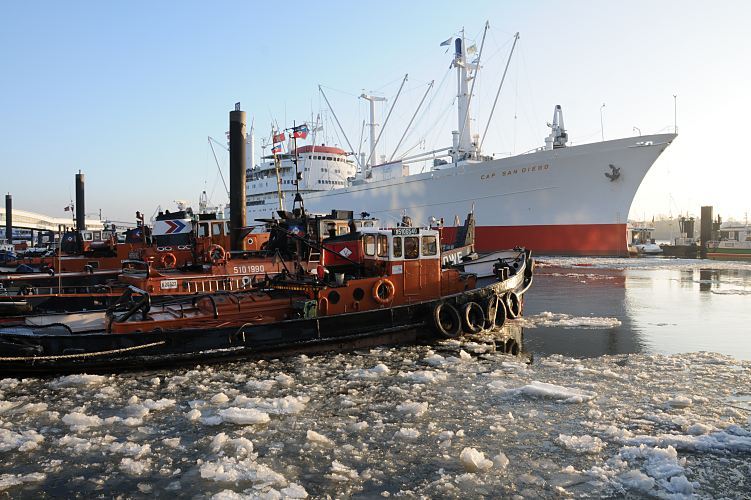 Hamburger Winter - Eis im Hafen, Museumsschiff Cap San Diego - Schlepper am Liegeplatz  011_26075 Schlepper liegen bei den Landungsbrcken; auf dem Wasser des Hafens schwimmen Eisschollen. Das ehemalig Frachtschiff Cap San Diego liegt an der berseebrcke - es ist seit 1988 Museumsschiff. Seit 2003 steht der 1961 gebaute Stckgutfrachter unter Denkmalschutz. www.hamburg-fotograf.com