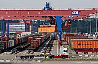 011_15671 Blick auf den Gterbahnhof vom Container Terminal Altenwerder; im Vordergrund ein leerer Lastzug; grosse Bahnkrne berspannen die Bahngleise und beladen die einzelnen Waggons mit ihrer Containerfracht. Der Bahnkran transportiert den Container vom Transportchassis zum Gterzug.