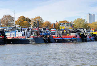 2934 Blick ber den Peutehafen - ein Schubschiff und Lastkhne, Schuten liegen am Ufer; im Hintergrund der historische Wasserturm in Hamburg Rothenburgsort auf der gegenber liegenden Seite der Norderelbe.