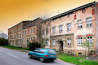 4282 Alte Wohnblocks - renovierungsbedrftige, verfallene Wohnhuser - Strasse mit fahrendem Auto; Bilder aus der Hansestadt Anklam.