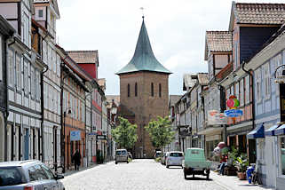 7385 Blick durch die Kirchstrasse in Lchow zum Kirchturm der St. Johanneskirche. Fachwerkhuser mit Wohnungen und Geschften.