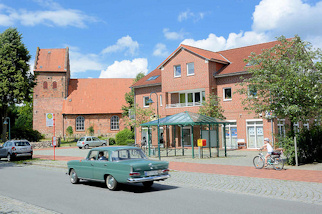 7329 Am Markt von Slfeld - historische Slfelder Kirche - schlichter Neubau, Bushaltestelle mit Metall-Wartehuschen.