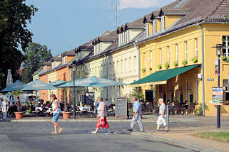 0485 Historische einstckige Wohnhuser mit Mansardenfenstern - Restaurant im Erdgeschoss, Gste sitzen an Tischen im Freien - Schlossplatz Rheinsberg.