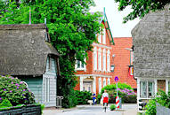 2896 Dorfstrasse in Hamburg Curslack - historische Huser am Strassenrand; Fahrradfahrerin.