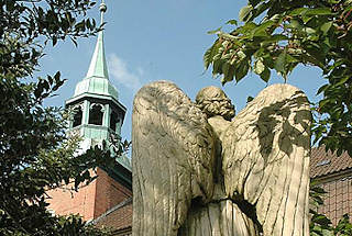 7901 Friedhof der Ochsenwerder St. Pankratius Kirche - Friedhofsengel - Steinskulptur eines Engels auf einem Grabstein.