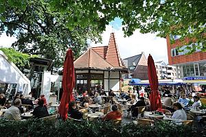 Eiscaf in der Rahlstedter Bahnhofstrasse - Tische auf der Terrasse an der Fussgngerzone.  Fotografien aus den Hamburger Stadtteilen und Bezirken - Bilder von Hamburg RAHLSTEDT, Bezirk Hamburg WANDSBEK. Die erste urkundliche Erwhnung als Radoluestede erfolgte 1248. Rahlstedt lag am stlichen Rande der Stadt Hamburg, gehrte zum Herzogtum Holstein unter dnischer Krone und fiel mit ihm 1864 an Preuen. 1927 wurden die Ortschaften Altrahlstedt, Neurahlstedt, Meiendorf und Oldenfelde sowie Teile von Tonndorf-Lohe und Jenfeld zur preuischen Gemeinde Rahlstedt zusammengeschlossen und kamen nach dem Gro-Hamburg-Gesetz 1937 zu Hamburg. Auf einer Flche von 26,6 km leben ca. 86 000 Einwohner.