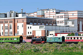 4017 Industriearchitektur im Magdeburger Hafengebiet - Ziegelgebude mit weiss abgesetzter Fassade der 1930er Jahre - historische Eisenbahnwaggons, Lokomotive.