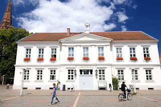 7698 Rathaus von Pritzwalk - errichtet ca. 1840 im sptklassizistischen Baustil; lks. der Kirchturm der Pfarrkiche St. Nikolai.