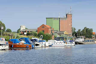 5851 Hafen von Bleckede an der Elbe; Sportboote in der Marina, ein Binnenschiff liegt am Hafenkai. Speichergebäude / Silo und Wohnhäuser am Hafenrand.
