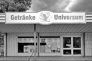 1295 (2) Schwarz-Weiss Fotografie - Laden in Dömitz / Elbe; Schild Getränke Universum - Atomsymbol, Umlaufbahn von Elektronen eines Atoms um den Kern - hier Bierglas.