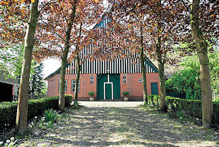 1452 Kopfsteinpflaster, Ahornbume mit jungen Blttern - historisches Bauernhaus in Neuendorf b. Elmshorn.