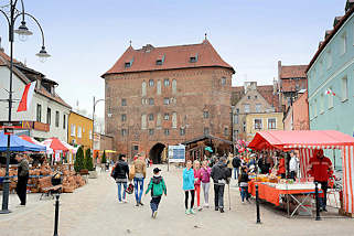 0131 Geschftsstrasse in Lidzbark Warmiński / Heilsberg - Verkaufsstnde in der Fussgngerzone - im Hintergrund das Hohe Tor, Teil der alten Befestigungsanlage der Stadt.