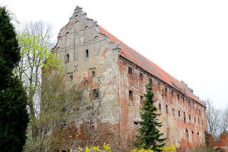 0119 Ruine Schloss, Burgruine in Mehlsack / Pieniężno, Polen. Ziegelgebäude, Backsteinarchitektur, der Putz ist abgeblättert.