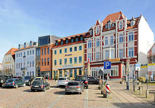4874 Restaurierte Wohnhäuser / Geschäftshäuser am Markt von Bergen auf Rügen; Parkplatz, parkende Autos / PKW.