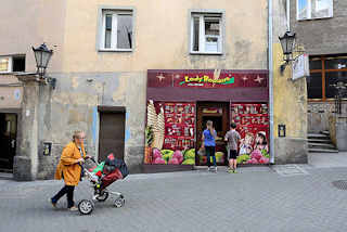 141_5474 Eisdiele / Eisverkauf mit bunter Fassade, Eissorten - Kinder vor dem Geschäft, graue Hausfassaden in Kłodzko / Glatz.