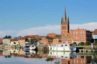 1112 Stadthafen von Grabow an der Elde am Abend - Sportboote haben als Gastlieger an der Kaimauer angelegt - Kirchturm der St. Georg Kirche.