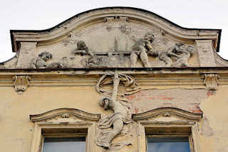 3293 Hausfassade, abbrckelnder Putz in der Strae Havlčkova in Dvůr Krlov nad Labem / Kniginhof an der Elbe - ehem. Grand Hotel; betrunkene / trunkene Putten die an der Weinpresse arbeiten - in erotischer Umarmung oder schlafend 