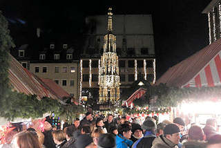 1203 MarktbesucherInnen zwischen Verkaufsständen auf dem Nürnberger Christkindlesmarkt - im Hintergrund der 1396 errichtete Schöner Brunnen.