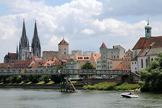 2979 Panorama der Altstadt von Regensburg - lks. die Türme des St. Peter Doms, in der Bildmitte der Uhrturm des alten Rathauses; rechts die evangelisch lutherische Kirche St. Oswald. Ein Motorboot fährt auf der Donau beim eisernen Steg.