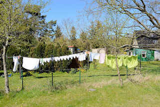 180_6758 Wohnhaus mit einzelnd stehenden Einraum-Ferienhäusern - Wäsche hängt zum Trocknen auf der Leine; Ostseebad Zingst, Mecklenburg-Vorpommern.